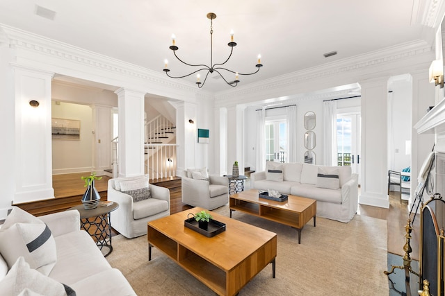 living room featuring crown molding, an inviting chandelier, and light hardwood / wood-style flooring