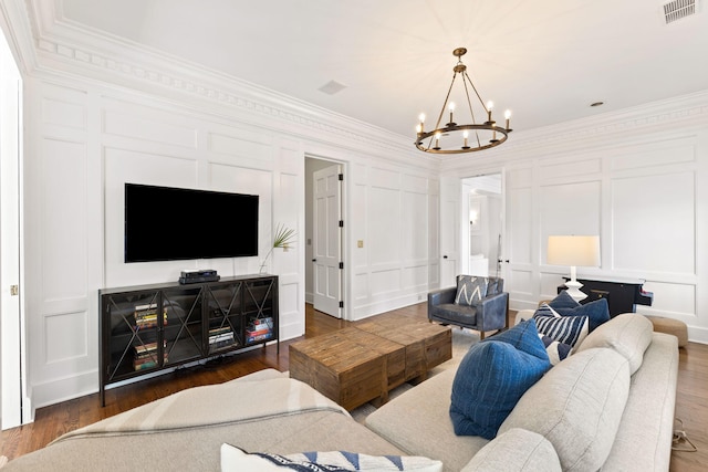 living room with dark hardwood / wood-style flooring, crown molding, and a notable chandelier