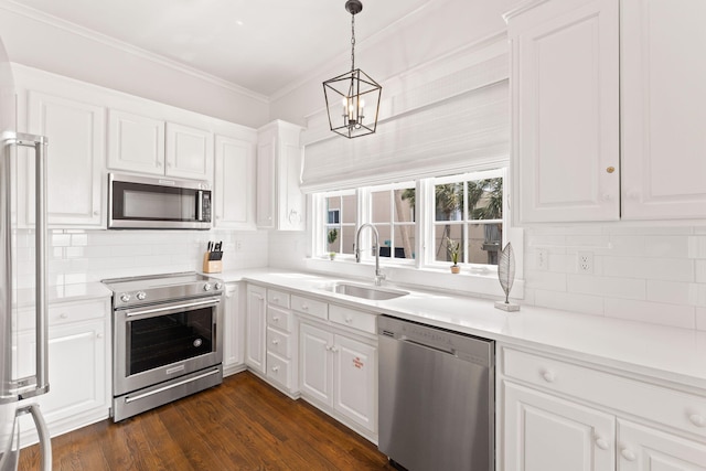 kitchen with light countertops, appliances with stainless steel finishes, a sink, and white cabinets