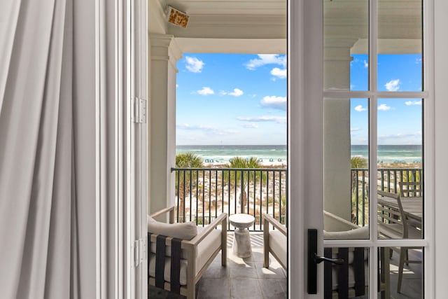 balcony featuring a view of the beach and a water view