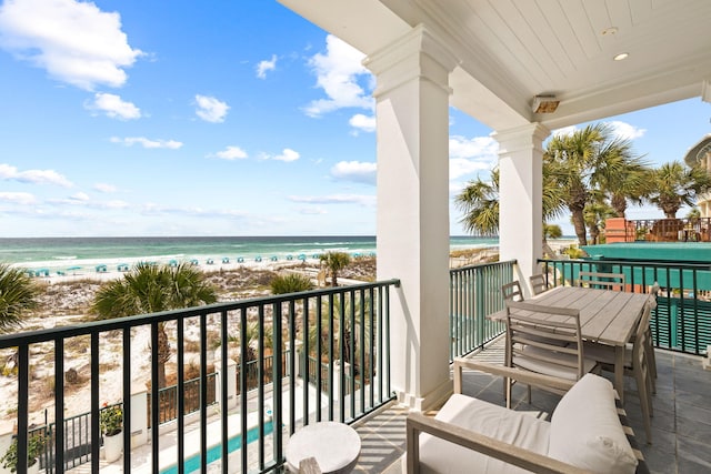 balcony featuring a view of the beach and a water view