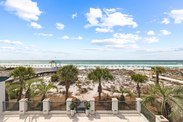 view of water feature featuring a gate and a beach view