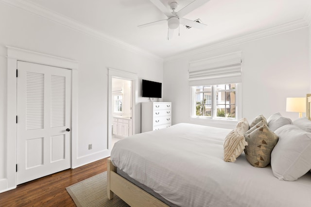 bedroom featuring ornamental molding, dark wood-style flooring, baseboards, and ensuite bathroom