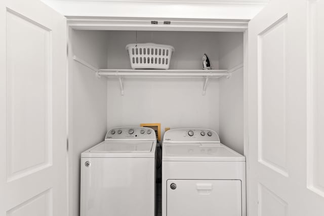 clothes washing area featuring laundry area and washer and clothes dryer