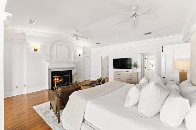 bedroom with hardwood / wood-style flooring, crown molding, and ceiling fan