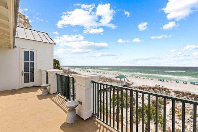 balcony featuring a water view and a view of the beach