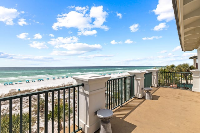 balcony with a water view and a view of the beach