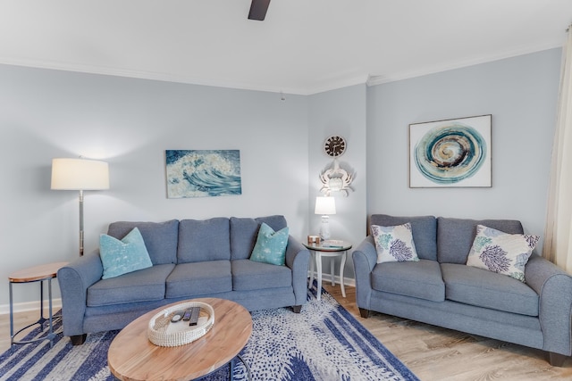 living room with ornamental molding, ceiling fan, baseboards, and wood finished floors