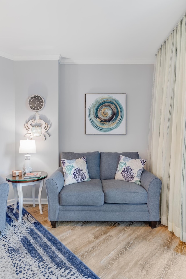 living room featuring ornamental molding, baseboards, and wood finished floors