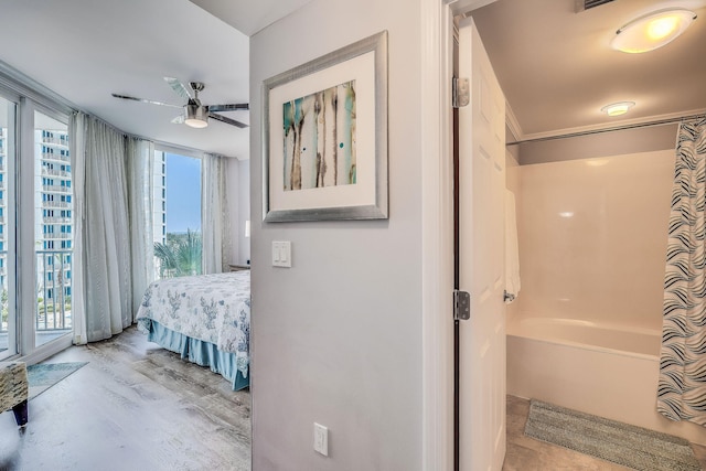 ensuite bathroom with ceiling fan, ensuite bath, wood finished floors, and a bathing tub