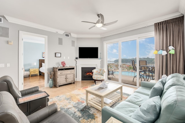 living room with ornamental molding, ceiling fan, and light tile floors