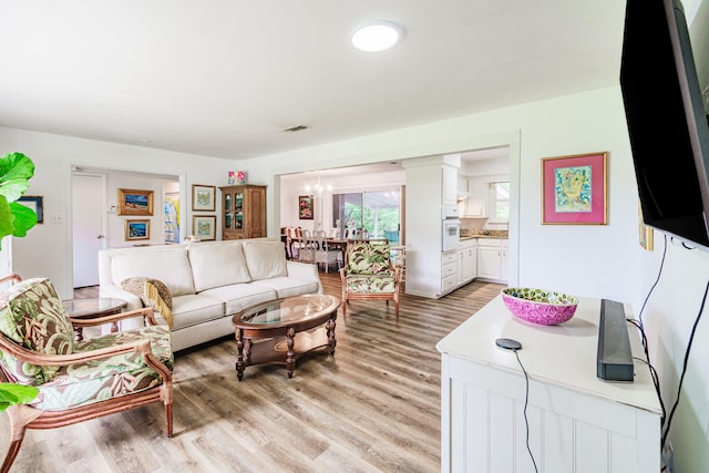 living room with a notable chandelier and light hardwood / wood-style floors