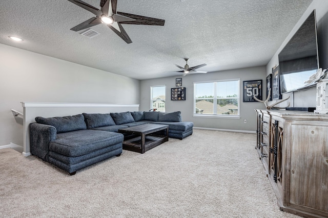 living room with ceiling fan, light colored carpet, and a textured ceiling