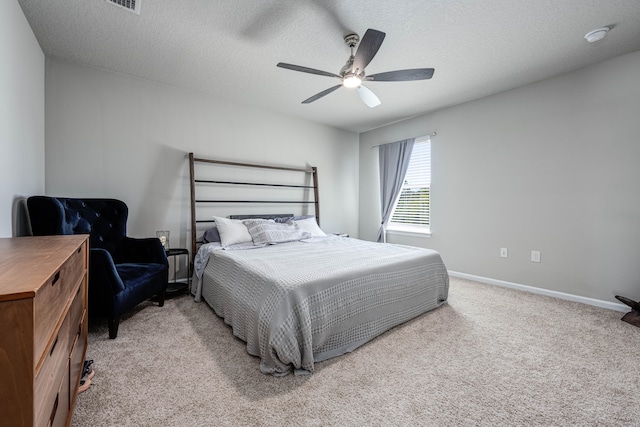 bedroom with a textured ceiling, ceiling fan, and light colored carpet