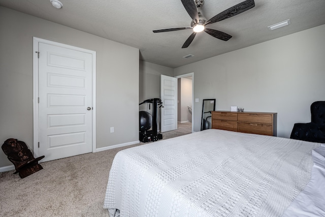 carpeted bedroom featuring ceiling fan and a textured ceiling