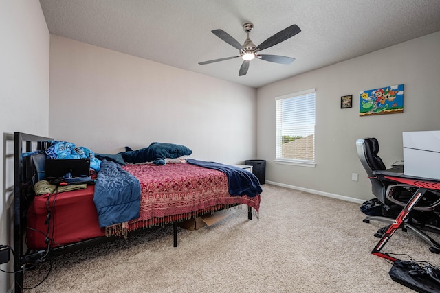 carpeted bedroom featuring ceiling fan and a textured ceiling