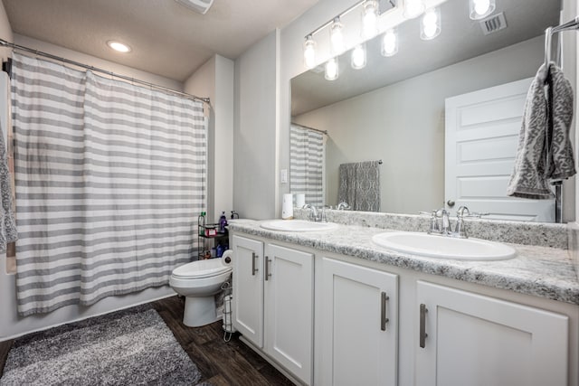 full bathroom featuring vanity, hardwood / wood-style floors, toilet, and shower / bath combo