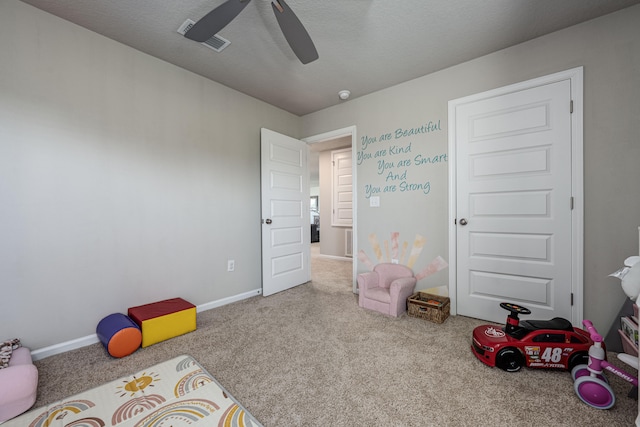 game room featuring ceiling fan, light colored carpet, and a textured ceiling