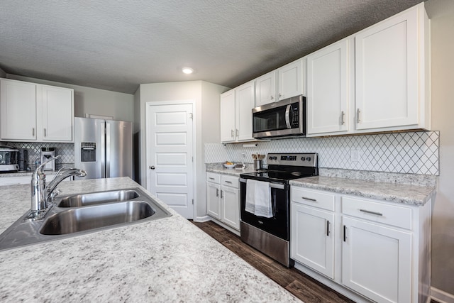 kitchen featuring white cabinetry, appliances with stainless steel finishes, dark wood-type flooring, and sink