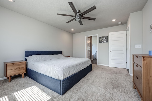 carpeted bedroom with connected bathroom, ceiling fan, and a textured ceiling