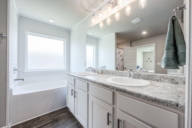 bathroom featuring shower with separate bathtub, hardwood / wood-style floors, a textured ceiling, and vanity