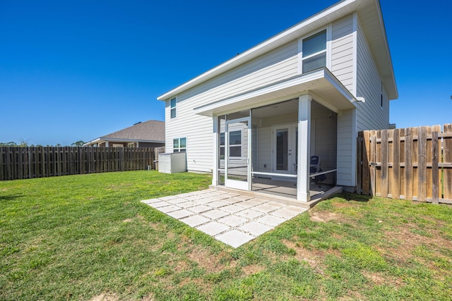 rear view of property featuring a sunroom, a yard, and a patio