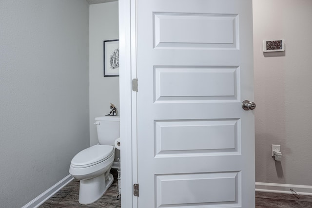 bathroom featuring wood-type flooring and toilet