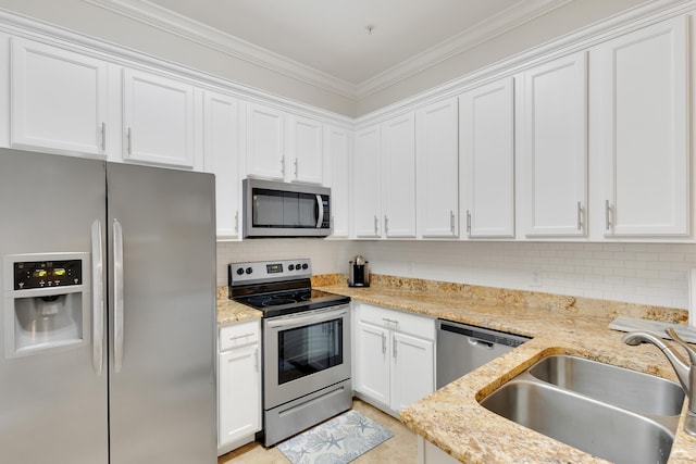 kitchen featuring white cabinetry, ornamental molding, stainless steel appliances, sink, and light stone counters