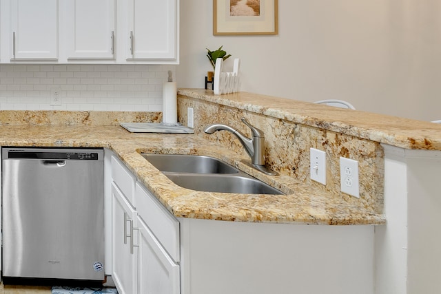 kitchen featuring light stone counters, white cabinets, sink, dishwasher, and backsplash