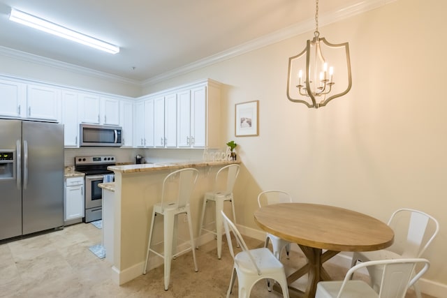 kitchen with light stone counters, appliances with stainless steel finishes, white cabinetry, and pendant lighting