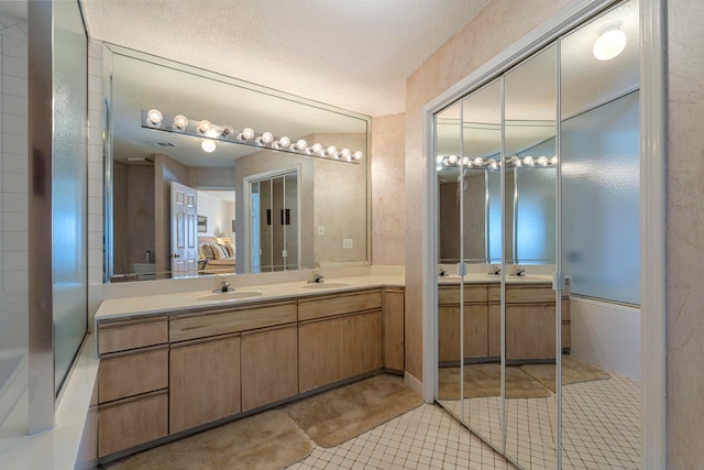 bathroom featuring double vanity, tile floors, and a textured ceiling