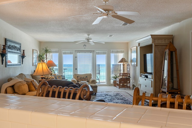 unfurnished living room with ceiling fan, carpet, and a textured ceiling