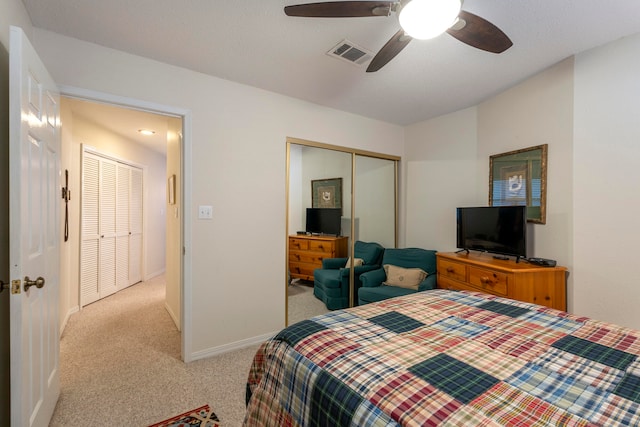 bedroom with a closet, light carpet, and ceiling fan