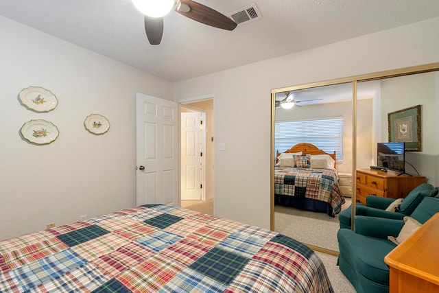 carpeted bedroom featuring a closet and ceiling fan