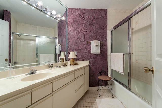 bathroom featuring a textured ceiling, vanity, enclosed tub / shower combo, and tile flooring