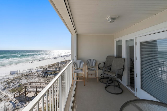 balcony featuring a water view and a beach view