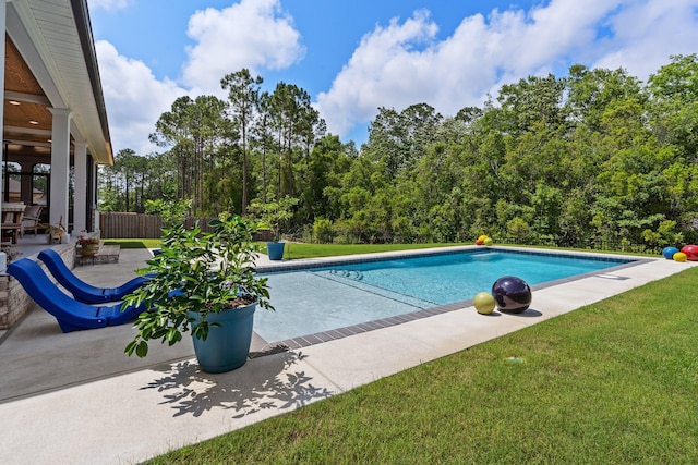 view of pool featuring a patio and a yard