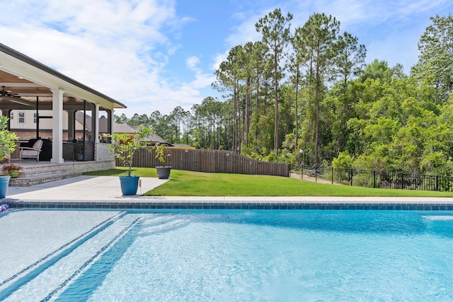 view of swimming pool featuring a patio and a yard