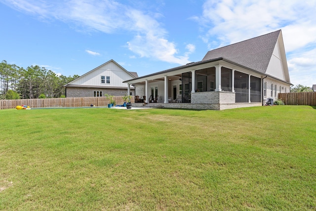 back of house with a patio, a sunroom, and a lawn