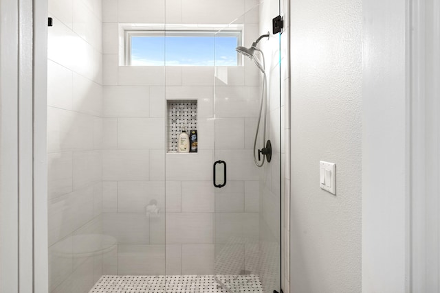 bathroom with a shower with door and toilet