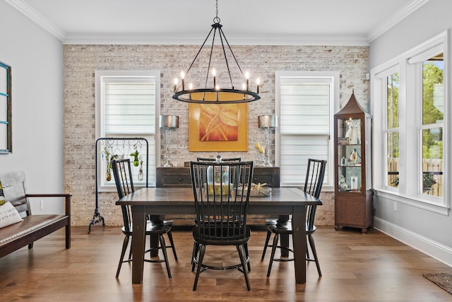 dining area with hardwood / wood-style flooring, an inviting chandelier, and ornamental molding