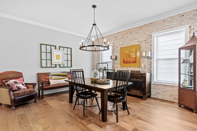 dining room featuring ornamental molding, an inviting chandelier, light hardwood / wood-style flooring, and a wealth of natural light