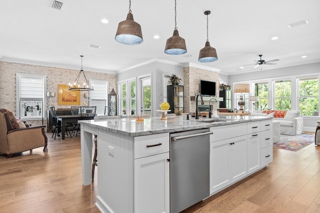 kitchen featuring a healthy amount of sunlight, light hardwood / wood-style flooring, dishwasher, and a kitchen island with sink