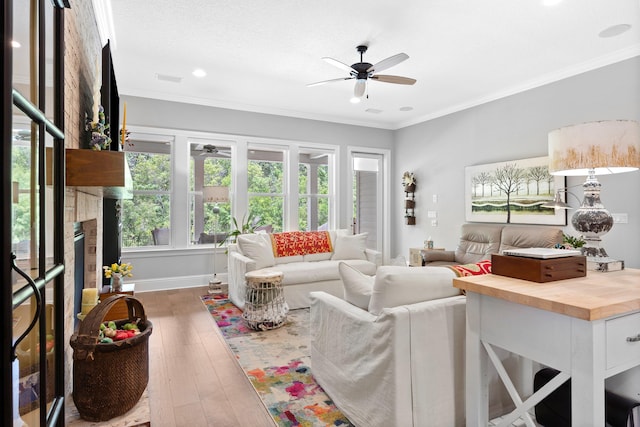 living room with ornamental molding, ceiling fan, and hardwood / wood-style flooring