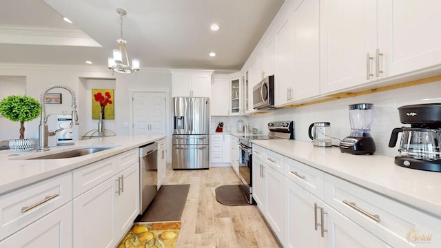 kitchen with light hardwood / wood-style floors, white cabinetry, hanging light fixtures, a chandelier, and stainless steel appliances