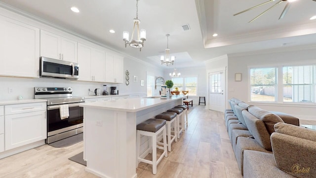 kitchen featuring light hardwood / wood-style flooring, electric stove, a wealth of natural light, and a breakfast bar