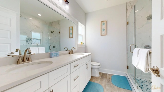 bathroom with oversized vanity, double sink, walk in shower, toilet, and wood-type flooring