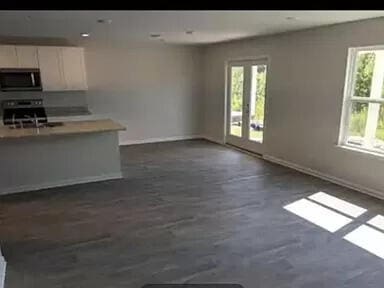 kitchen featuring white cabinets, plenty of natural light, french doors, and stove