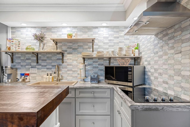 kitchen with backsplash, sink, and wall chimney exhaust hood