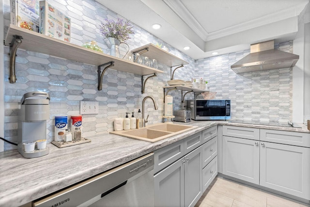 kitchen featuring appliances with stainless steel finishes, wall chimney exhaust hood, sink, tasteful backsplash, and crown molding